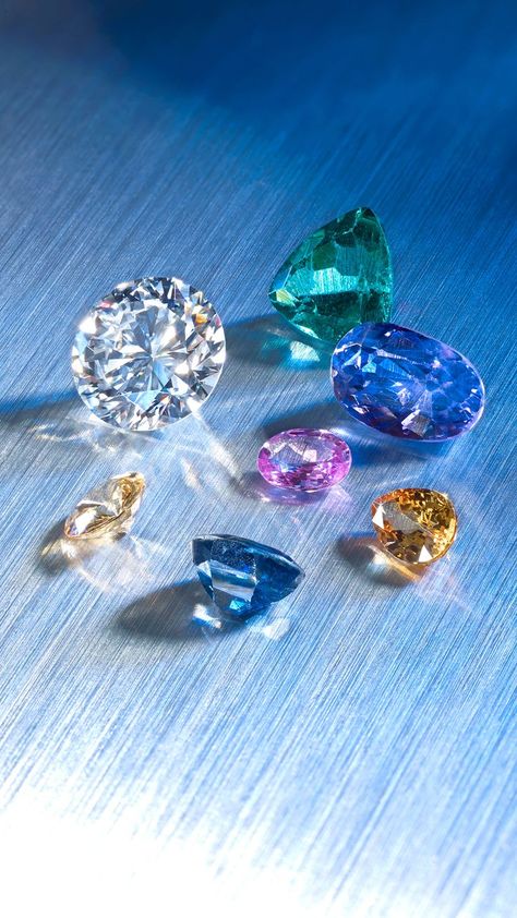 A variety of sapphires, a brilliant-cut diamond and a triangular shape apatite. Gemstones Photography, Gem Wallpaper, Diamond Image, Rainbow Carrots, Bling Wallpaper, Expensive Jewelry Luxury, Diamond Jewelry Designs, Expensive Jewelry, Colored Gems