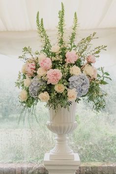 Floral urns are perfect for creating that romantic feel for a wedding ceremony. Beautiful Family Homes, Vintage Flower Arrangements, Pastel Wedding Theme, Church Wedding Flowers, Table Arrangements Wedding, Tall Wedding Centerpieces, Large Flower Arrangements, Church Flower Arrangements, Wedding Altars