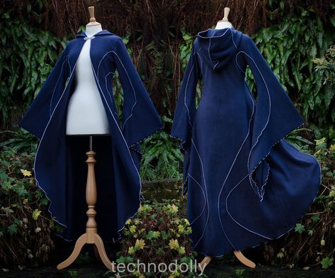 ~ Haunted Hawtin Cloak ~ Made to Measure ~ The floor length Haunted Hawtin Cloak is a simple & beautiful design. Made using soft fleece fabric with elegant trim detail to create a delicate flowing line of colour & form. It is floor length with large medieval flared sleeves, a open front with a single clasp fastening at the throat & rounded hood. Colours used in photos: Midnight Blue with Silver Grey detail. *From Petite Pixies to Rubenesque Goddesses. Whatever shape you take I can ac Fantasy Clothing Inspiration, Space Cloak, Blue Fantasy Outfit, Dark Blue Cloak, Star Cloak, Cloak With Sleeves, Dragon Cloak, Hooded Cloak Pattern, Long Blue Coat