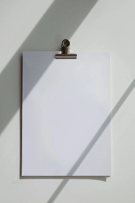 A Blank Bond Paper on a White Surface · Free Stock Photo Casting Shadows, Bond Paper, Creative Content, Clipboard, A Metal, 로고 디자인, Social Media Template, White Paper, Paper Clip