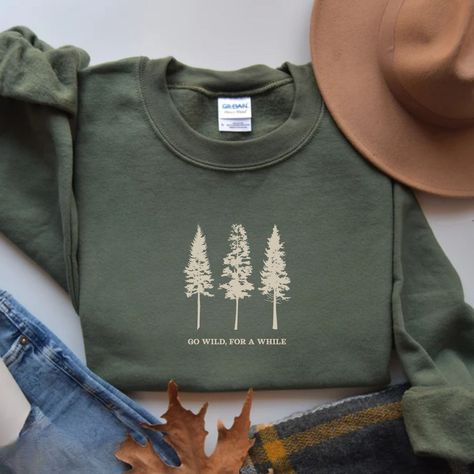 Embrace the spirit of adventure with our Pine Tree Sweatshirt featuring the phrase "Go Wild, For a While" and a stunning graphic. Perfect for nature lovers, this hiking and camping crewneck makes an ideal gift for granola girls and travel enthusiasts who crave the great outdoors and the freedom of the wilderness. Prefer this design on a T-Shirt? Visit this link: https://bohemianbloomdesigns.etsy.com/listing/1772284433 Prefer this design on a Hoodie? Visit this link: https://bohemianbloomdesigns. Cricut Sweatshirt Ideas, Outdoorsy Shirt, Camping Hoodie, Baggy T-shirt, Hiking And Camping, Hiking Tshirt, Mountain Shirt, Mama Style, Granola Girl