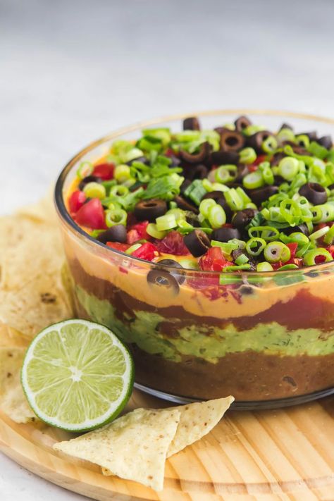 This Vegan Seven Layer Dip is made of layers of Refried Beans, Guacamole, Queso, and more...making it a perfect appetizer or party treat! Gluten Free & Oil Free #vegan #plantbased #dip #partydip #healthyappetizer #appetizer #sevenlayerdip #refriedbeans #guacamole #glutenfree #gameday #potluck via frommybowl.com Vegan Appetizers Recipes, Vegan Potluck, Seven Layer Dip, Vegan Party Food, Vegan Party, Vegan Mexican Recipes, Vegan Dip, Layer Dip, Vegan Mexican