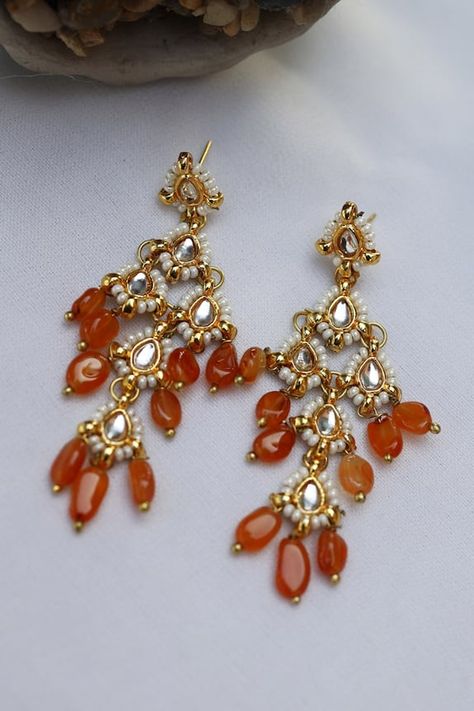 Gold plated dangler earrings with kundan embellishment, pearl highlights on the edge and orange stone drops. Type: Stone and Kundan Composition: Silver Alloy Color: Orange Other Details:  Dimension L x B (in cms): 6 x 2.5 Weight (in gms): 25 Closure: Push back clasp  - Aza Fashions Pearl Highlights, Jayanti Reddy, Orange Saree, Diana Penty, Dangler Earrings, Orange Stone, Earring Collection, Kundan Earrings, Luxury Sale