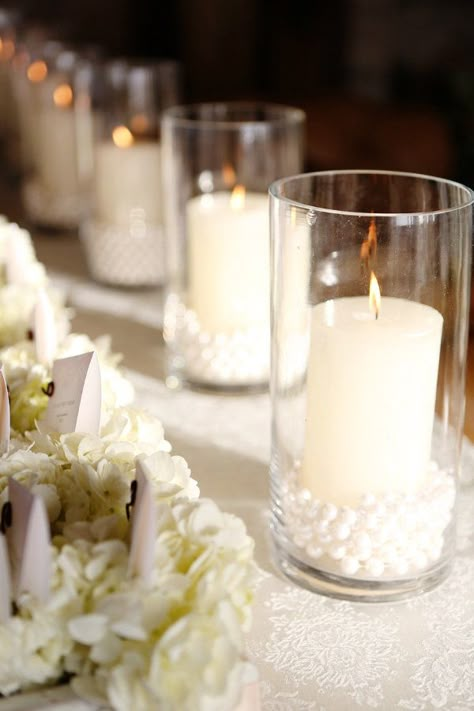 Candles with pearls Tablescape Centerpiece www.tablescapesbydesign.com https://www.facebook.com/pages/Tablescapes-By-Design/129811416695 Flowers And Candles, Pearl Centerpiece, Gladioli, Wedding Help, Glass Vases, Online Wedding, Pearl Wedding, Here Comes The Bride, Hollywood Glamour