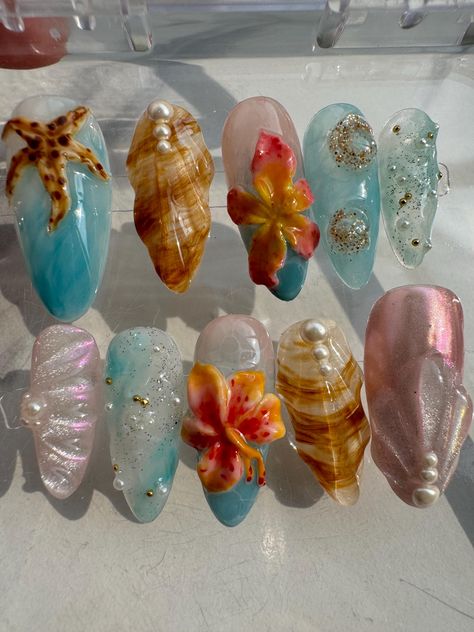 About this item: Dive into the Tropics: Our medium almond press-on nails are your ticket to a tropical paradise! Adorned with ocean-inspired elements like starfish, seashells, and vibrant tropical flowers, these nails are perfect for capturing that summer vibe all year round. Easy, Breezy, Beachy: These nails are not only reusable and lightweight, but they're also super easy to apply, giving you a salon-quality manicure in minutes. Whether you're dreaming of the beach or just want to add a splas Summer Nails Charms, Cute Nails Beach, Hawai’i Nails, Hawaii Theme Nails, Vacation Nails Short Almond, Blue Beachy Nails, Nail Inspired Almond, Beach Aesthetic Nails, Water Themed Nails