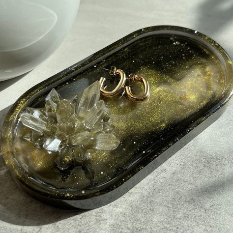 Introducing our exquisite epoxy resin jewelry tray - the perfect storage solution and gift for the most sophisticated woman in your life. The expertly crafted oval shaped stand combines elegance and practicality to create a truly one-of-a-kind accessory. Featuring vibrant crystals encased in flawless epoxy resin, this eye-catching tray not only displays your precious jewelry but also adds an artistic touch to your dresser or vanity. Crystals serve both as decoration and as a stand for rings.   Surprise your girlfriend, wife, or loved one on their birthday or special occasion with this enchanting gift they'll cherish and adore. Sophisticated, functional, and undeniably striking - why settle for ordinary when you can make an unforgettable impression with our  Epoxy Jewelry Tray?  Length 7 in Resin Dresser, Resin Tray Ideas, Resin Jewelry Tray, Epoxy Resin Jewelry, Surprise Your Girlfriend, Tray Ideas, Oval Tray, Epoxy Resin Crafts, Jewelry Tray