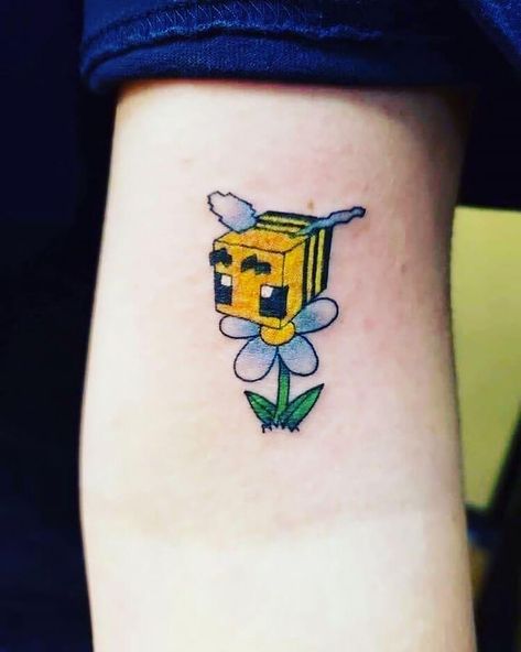 This Minecraft tattoo idea features a cute bee design with a flower. In Minecraft bees are flying neutral mobs that live in bee nests and beehives. If provoked, bees attack in a swarm to "sting" the player and inflict poison. Minecraft Tattoo Ideas, Minecraft Tattoo, Nerdy Tattoos, Beginner Tattoos, Tatuaje A Color, Gaming Tattoo, Bee Tattoo, Matching Tattoo, Dream Tattoos