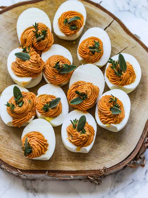 Thanksgiving Deviled Eggs are an easy appetizer party food idea. Gorgeous Fall color, garnished with sage and thyme to celebrate the season. Birthday On Thanksgiving Ideas, Fall Crowd Food, Thanksgiving Amount Of Food, What Order To Cook Thanksgiving Dinner, Thanksgiving Feast Aesthetic, Friendsgiving Dinner Party Appetizers, Thanksgiving Table Setting With Food, Thanksgiving For 6 People, Bon Appetit Thanksgiving