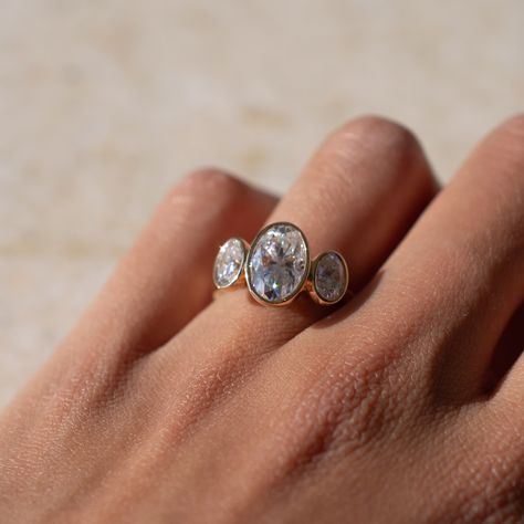 This alternative style three stone oval engagement ring features a full bezel setting for each stone, lifted onto the finger for a grand finish. Sublime 🤍 Details: - 2ct oval moissanite centre - 2x 0.4ct oval moissanite accent stones - 18k yellow gold - 2mm wide shank #engagementringdesign #customengagementring #bespokeengagementring #threestoneengagementring #moissaniteengagementring #nz #aus Bezel Three Stone Engagement Ring, Three Stone Bezel Set Ring, Three Stone Oval Engagement Ring, Oval Engagement Ring, Bezel Engagement Ring, Bespoke Engagement Ring, Bezel Set Ring, Alternative Style, Oval Moissanite