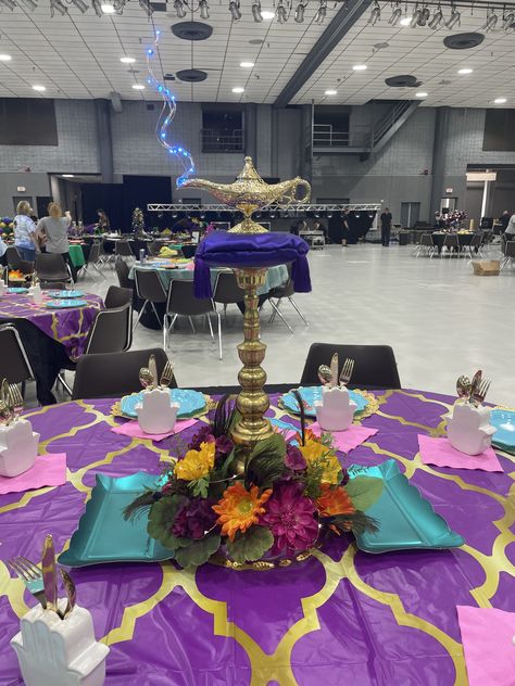 Created with satin pillows and foam carved to pillow shapes, blue LED lights on a silver wire, brass lamp, brass candlestick and silk flowers on a gold metallic plastic tray. I also added warm white LEDs to the flowers. This was for a Mardi Gras event. Got lots of nice compliments. Arabian Nights Dance Theme, Arabian Centerpieces, Aladdin Centerpiece Ideas, Arabian Nights Homecoming, Arabian Nights Quinceanera Theme, Arabian Nights Centerpieces, Arabian Nights Prom Theme, Arabian Nights Party Decorations, Hoco Decor