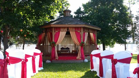 gazebo draped in reds and golds for outdoor wedding ceremony Gazebo Drapes, Gazebo Wedding Ceremony, Gazebo Decorations, Wedding Ceremony Decorations Outdoor, Red Drapes, Gazebo Wedding, Outdoor Gazebos, Outdoor Wedding Ceremony, Wedding Ceremony Decorations