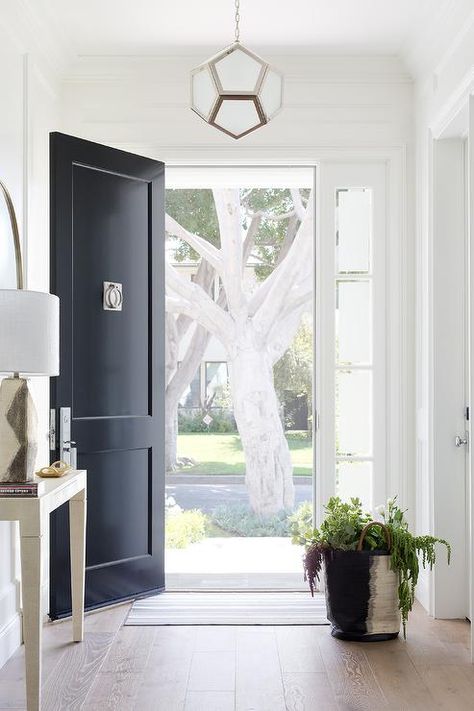 Robert Abbey Mary McDonald Pythagoras Pendant elegantly on display in the entrance hall of an entry foyer completed with a black front door, a modern nickel knocker, and sidelights. Apartment Foyer Ideas, Black Front Door With Sidelights, Apartment Entrance Door, Apartment Foyer, White Front Door, Apartment Entrance, Black Front Doors, Entrance Foyer, Foyer Decorating