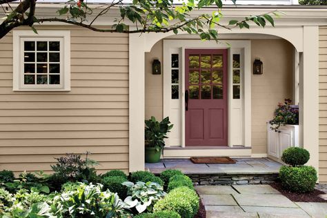 26 Exterior Tan Color Schemes That Pros Turn to Over and Over Again Tan Sided House Color Schemes, Tan House Exterior Door Color, Porch Colors For Tan House, Tan House Colored Door, Tan House Brown Roof, Shutter Colors For Beige House, Light Yellow Exterior House Colors, Sw Natural Tan Exterior, Tan Cottage Exterior