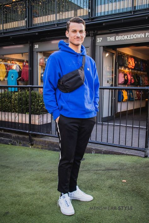 We snap Jonny on the streets of London wearing a sportswear outfit featuring a blue Champion hoodie and black shoulder bag. Champion Hoodie Outfit, Blue Hoodie Outfit, Blue Outfit Men, Blue Champion Hoodie, Hoodie Outfit Men, Sportswear Outfits, Streets Of London, Street Style Trends, Champion Hoodie