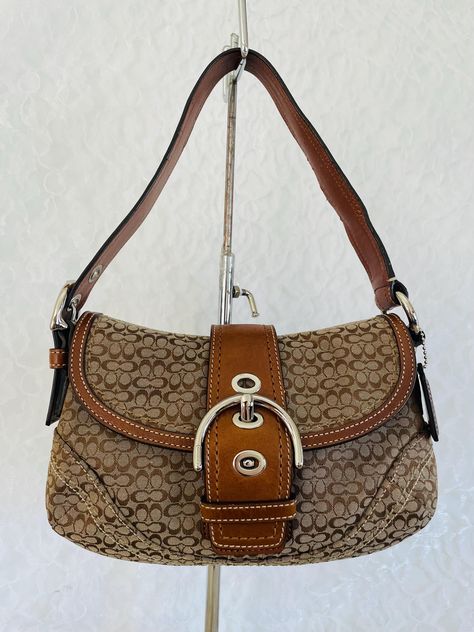 Vtg Coach Purse Shoulder Handbag soho bag 100% authentic , good vtg condition  Color: Brown Made of jacquard and genuine leather Silver tone Hardware Snap Belted buckle closure detachable shoulder strap Grossgrain fabric interior Very clean interior / exterior 10"L x 7"H x 2.5"D PLEASE INSPECT PICTURES WELCOME ANY QUESTIONS BEFORE CHEK OUT SORRY NO CANCELLATIONS / NO RETURNS Y2k Coach Bag, Coach Soho Bag, Unrealistic Wishlist, Vintage Coach Bag, Coach Hobo Bag, Vintage Designer Bags, Rhinestone Jeans, Aesthetic Ig, Brown Coach