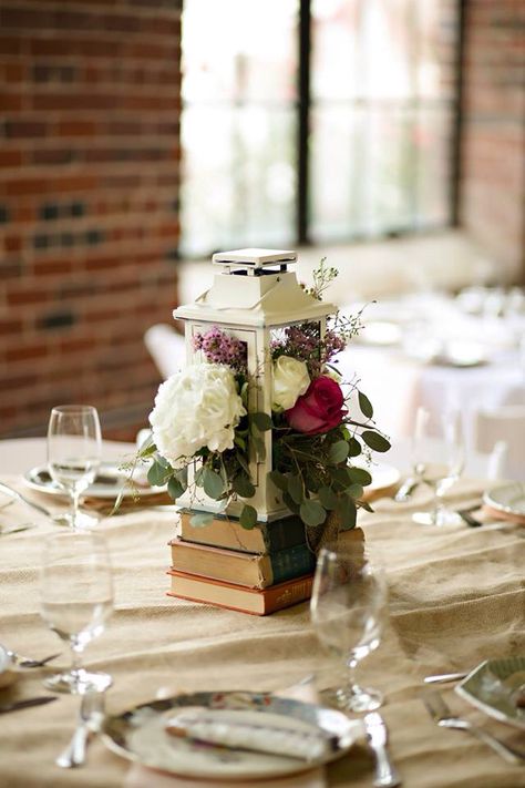 Diy Book Centerpieces Wedding, Book Lantern Centerpieces, Lantern Book Centerpiece, Books For Wedding Centerpiece, Book And Lantern Centerpieces, Old Book Centerpieces, Old Books Wedding Decor, Antique Book Centerpieces, Antique Centerpiece Wedding