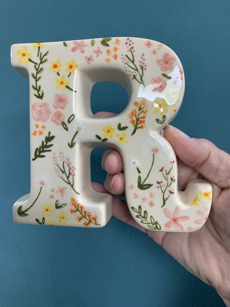 Beautifully delicate flowers painted at our pottery studio on a ceramic letter R Preppy Ceramics, Clay Crafts To Make For Your Boyfriend, Ceramic Letters Ideas, Preppy Pottery Painting, Flower Pottery Painting, Paint Your Own Pottery Ideas Easy, Initial Letter Decor, Clay Letters, Ceramic Letters