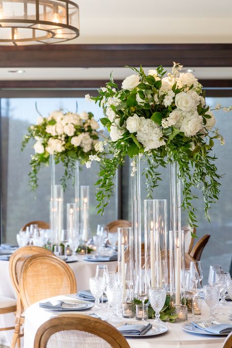 Glass Tall Centerpieces, Floral Risers Wedding, Acrylic Centerpiece Stand, Acrylic Tall Centerpieces, Tall Wedding Centerpieces With Candles, Harlow Stand Centerpiece With Candles, White Rose Centerpiece Round Table, Tall Centerpieces With Candles, Acrylic Wedding Centerpieces