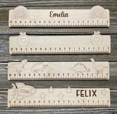 These cute themed wooden rulers are just over 20 cms wide.  Choose from: rainbows, apples, Dino's or space theme You can also choose for it to be personalized with your kids name, or blank as well!  Make sure to check our other listing for our back to school bundle: personalized ruler, bookmark and magnet! Back To School Laser Ideas, Wooden Lasercut Ideas, Lasercut Ideas, Market Day Ideas, Diy Vinyl Projects, Wood Laser Ideas, Wood School, Wooden Ruler, Laser Cut Wood Crafts