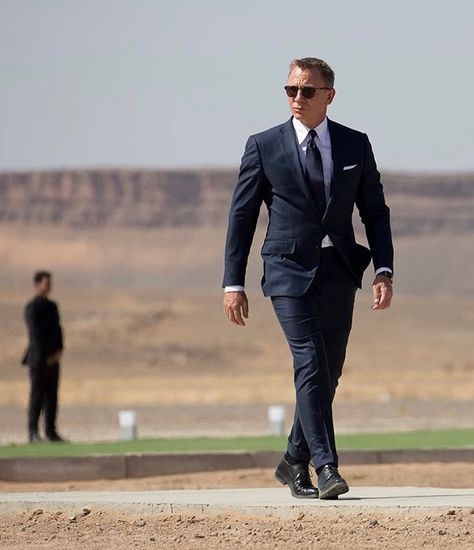 Spectre - Navy Sharkskin “O’Connor” suit. The jacket features straight, padded shoulders with roped sleeve heads. The front has three buttons with narrow notch lapels rolled to the middle button. The jacket is detailed with a single vent, slanted flapped hip pockets, a curved “barchetta” breast pocket and four button cuffs. The trousers are detailed with a wide extended waistband, slide buckle side-adjusters and narrow straight legs and turn-ups from @tomford - White cotton poplin shirt with... James Bond Quotes, Gentlemen Style, Sharkskin Suit, Bond Quotes, Hollywood Movies, Navy Suit, Suit Shirts, Daniel Craig, Cotton Poplin Shirt