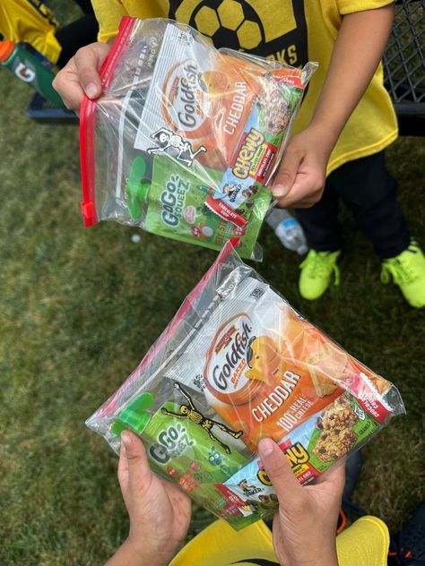 In a Ziplock bag, add a bag of Goldfish crackers, a Chewy granola bar, and a GoGo Apple Pouch for after game snacks. Snacks For T Ball Team, Kids Soccer Team Snack Ideas, Snack Ideas For Softball Team, Soccer Game Day Snacks, Snacks Bags Ideas, Volleyball Snack Bags Team Mom, Snack Bags For Sports Basketball, Kids Sport Snacks Team Mom, First Soccer Game Gift