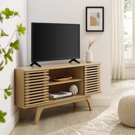 Tap into mid-century aesthetics with the Render 46 Corner TV Stand. Render features smooth walnut grain veneer, four solid wood tapered legs, non-marking foam foot pads, adjustable shelves, and two slatted sliding doors for sophisticated media storage. Complete with a cable management hole, Renders contemporary linear style is the perfect addition to the modern living room, lounge, or recreation area. With slanted sides, this corner media stand accommodates TVs up to 50". Assembly required. Size Corner Media Stand, Modern Corner Tv Stand, Corner Tv Console, Mid Century Tv, Corner Tv Stand, Corner Tv, Media Stand, Living Room Lounge, Storage Credenza