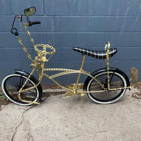 Gold twisted frame, flat twisted handlebars, flat twisted bent springer fork, flat twisted flared sissy bar, twisted pedals, black 20” wheels, black fenders, low rider 20” tires, gold chain link steering wheel. $1000 Low Rider Bike, Low Rider Bike Bicycles, Lowrider Bikes, Rider Bike, Lowrider Bicycle, Bicycle Tattoo, Beach Cruiser Bikes, Lowrider Bike, Power Bike