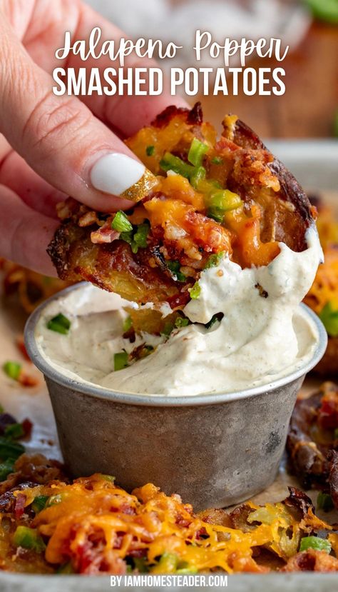 A hand is holding a smashed potato and dipping it into a creamy sauce in a silver cup. There are other smashed potatoes around it on parchment paper. Jalapeño Popper Smashed Potatoes, Food Truck Potatoes, Jalapeño Popper And Potato Chowder, Jalapeño Mashed Potatoes, Get Together Side Dishes, Football Season Dinners, Jalapeno Popper Baked Potato, Jalapeno Popper Potatoes, Smashed Potato Skins