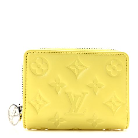 This is an authentic LOUIS VUITTON Lambskin Embossed Monogram Lou Coussin Wallet in Yellow. This soft wallet is crafted with yellow monogram embossed lambskin. It features card slots and bill compartment with silver hardware. The wallet also features a zippered coin compartment on the side.