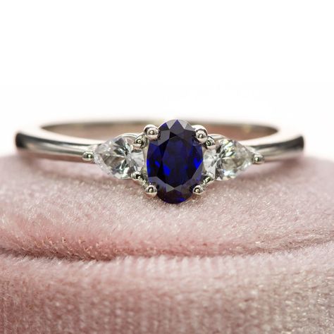 Elevate your engagement with the Tressa - Three Stone Prong Set Oval Lab Sapphire Engagement Ring, featuring a luxurious oval lab-grown blue sapphire as its centerpiece, surrounded by pear-shaped white sapphires on either side. Featuring 2 pear-shaped side white sapphires to frame a deep blue oval sapphire, this three-stone engagement ring embodies timeless beauty and attention to detail. Shop here: https://nodeform.com/products/tressa-three-stone-prong-set-oval-lab-sapphire-engagement-ring-w... Three Stone Sapphire Engagement Ring, Diamond And Sapphire Ring, Sapphire Wedding Band, Sapphire Band, Stunning Engagement Ring, Sapphire Engagement Ring, Three Stone Engagement Rings, Silver Engagement Rings, Detail Shop