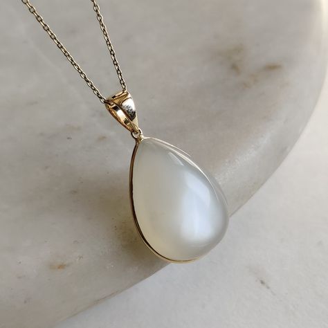 ITEM DESCRIPTION: >>The pendant is made from Solid 14K Yellow Gold. Gemstone used is absolutely natural and ethically sourced.  >>Natural White Moonstones in cabochon cut and pear shape with bezel setting are studded on it with utmost precision.  >>This is a minimalist design and is absolutely hassle-free and everyday jewelry.  ✓ Gem: White Moonstone ✓ Gem size: 17x24 mm  ✓ Gem weight: 29.86 carats ✓ Gold purity: 14K (58.33% approx.) ✓ Gold weight: 0.70 grams  ✓ Gross weight: 6.67 grams The Gold purity is guaranteed and it comes with authentic 14K gold hallmark. Since these Pendants are handmade, they are Nickel/Lead FREE.  CUSTOMIZATION: --> You can choose your own gemstone as well. --> Main Gemstone can be substituted with the gem of your choice. --> Kindly drop a message for the same. C Handmade Jewelry Box, White Moonstone, Bezel Pendant, Jewelry Lookbook, June Birthstone, Moonstone Jewelry, Moonstone Pendant, Unique Gemstones, June Birth Stone