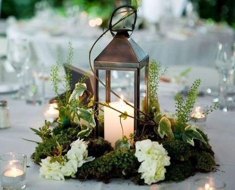 a metal candle lantern on a moss piece, with herbs and white blooms looks amazing for a woodland wedidng tablescape Non Floral Centerpieces, Moss Centerpieces, Moss Wedding, Winter Floral Arrangements, Lantern Centerpiece Wedding, Ceremony Candles, Enchanted Forest Wedding, Lantern Centerpieces, Wedding Floral Centerpieces