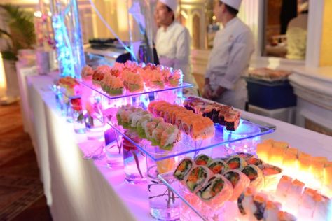 lit up sushi bar on glass and with flowers in glasses Sushi Platter Wedding, Sushi Bar Party Ideas, Sushi For Wedding, Sushi Bar Wedding Receptions, Sushi Bar At Wedding, Sushi Buffet Party, Sushi Bridal Shower Ideas, Sushi Bar Party, Sushi Bar Wedding