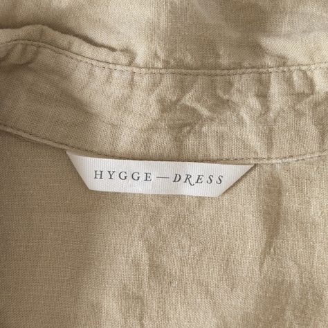 Logo that says Hygge Dress on a white label inside a shirt Dress Label Tag Design, Linen Branding Logo, Clothing Label Inspiration, Clothing Label Design Ideas Branding, Clothing Brand Label Design, Fashion Tags Label Design, Label Design Clothing Branding, Fabric Label Design, Clothes Label Design Tags