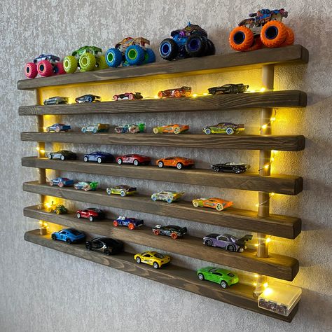 Toy Car Shelf: Show off your toy car collection with this wooden car shelf! We have combined 7 wooden shelves made of high quality wood. A unique product to display your toy cars! This would be the perfect birthday present for your loved ones!  The width of the wooden shelves is 2 inches. The distance between them is 1.75 inches. You can display about 60 toy cars with this product. Please message us if you would like to customize these dimensions. We can make it in any size you want. Product Dimensions:  30*18*2 inches.                                         76*46*5 cm. Personalization: Personalization is possible. We can laser engrave any word you want on the middle shelf.     We can customize product dimensions according to your wishes. Please message us for any customization request! T Hotwheels Storage Wooden, Tire Shelf For Hot Wheels, Cars Storage For Kids, Dinosaur Toy Display, Monster Truck Display Shelf, Toy Car Collection Display, Hotwheels Bedroom Ideas, Car Room Ideas For Boys, Boys Room Organization Ideas