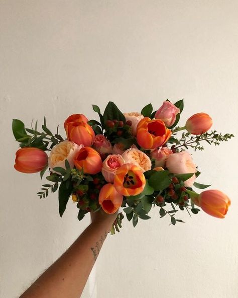 Picture of an extra bold spring wedding bouquet of orange tulips and blush peony roses plus berries and leaves can be rocked in the fall, too Green And Orange Bridal Bouquet, Fall Tulip Bouquet, Orange Blossom Wedding Bouquet, Tulips As Wedding Flowers, Orange Flowers Arrangements, Ranunculus Tulip Bouquet, Dahlia And Tulip Bouquet, Orange Peony Bouquet, Tulips Roses Bouquet