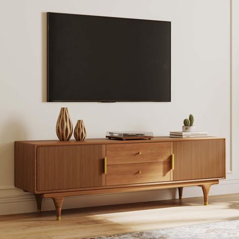 PRICES MAY VARY. Mid Century Modern TV Stand: Elevate your living space with our exquisitely crafted 70.87 inch TV stand featuring a medieval-modern design. The warm walnut finish adds a touch of sophistication to any room Fluted Door Design: The fluted door design adds a touch of sophistication to your storage spaces. The gold accents, including the door handles and copper foot caps, create a cohesive and luxurious look throughout the media console Spacious Storage: With two drawers in the cent Short Media Console, Tv Console Tables In Living Room, Midcentury Modern Media Cabinet, Southwest Tv Stand, Tv Stand With Record Storage, Funky Media Console, Walnut Furniture Living Room Decor, Light Wood Furniture Living Room, Living Room With Sideboard