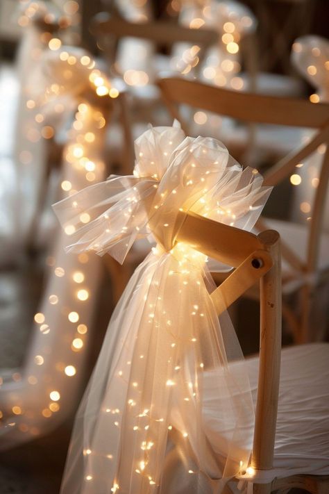 Transform your wedding into a fairytale with these stunning chair decorations. Tulle sashes and fairy lights add an ethereal touch to your reception. ✨🎀💡 Easy DIY setup for a night of wonder. #WeddingInspiration #FairyLights #DIYWedding #WeddingDecor #TulleDecorations #MagicalEvening #BridalStyle #WeddingChairDecor Let the romance sparkle! Nighttime Wedding Send Off, Tulle And Fairy Lights, Wedding Twinkle Lights, Fairy Light Wedding, Wedding Fairy Lights, Twinkle Lights Wedding, Wedding Chair Decor, Tulle Decorations, Christmas Wedding Inspiration