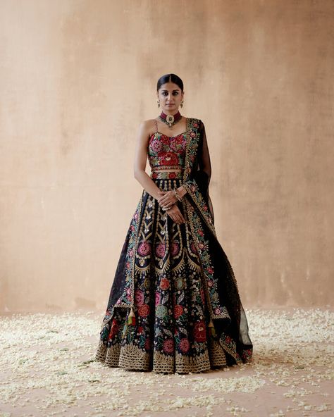 A festive collection where each ensemble is unconventional; while revealing the playfulness & contemporisation hidden in the exquisite ancient craftsmanship of India, each silhouette reflects the uniqueness within a modern Indian woman. Floral Embroidery Lehenga, Floral Thread Embroidery, Embroidery Lehenga, Raw Silk Lehenga, Black Lehenga, Indian Bridal Outfits, Ethnic Outfits, Silk Lehenga, Black Thread