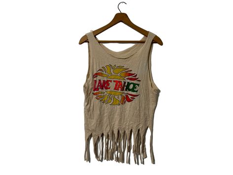 "80's Lake Tahoe Graphic Tank Fringe Crop Top  ☆ SIZE: Women's Medium ☆ MEASUREMENTS (while lying flat, inches): ✄ Length: 26\" total length, 20\" without fringe ✄ Width (armpit to armpit): 18\" ☆ MATERIAL: Cotton, Polyester  ☆ COLOR: Beige ☆ NOTES: This item is vintage and has been previously loved. There are some faded bleach spots and some subtle stains.  Thanks for checking out this listing! Be sure to visit The Bearded Bee for other unique items! www.etsy.com/shop/thebeardedbee" Fringe Crop Top, Fringe Tank Top, Graphic Crop Top, Tan Woman, Top Vintage, Cropped Tube Top, Handmade Boho, Unique Items, Lake Tahoe