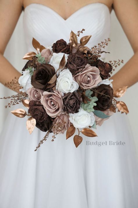 This magnificent rounded brides’ bouquet is crafted using mauve, brown and white roses of the highest quality. This elegant bouquet is sure to leave a lasting impression. The delicate brown glitter roses in this collection, create a bright and dazzling arrangement that is sure to turn heads. With a mixture of gold foliage and greenery this bouquet is sure to make a statement. All of our bouquets are a wonderful option for destination weddings, as they can be bought in advance and easily stored a Bronze And Cream Wedding, Brown Bouquet Wedding, Dusty Rose And Brown Wedding, Brown Aesthetic Wedding Theme, Brown And Rose Gold Wedding, Light Brown Wedding Theme, Brown And Gold Wedding Theme, Shades Of Brown Wedding, Mocha Wedding Theme