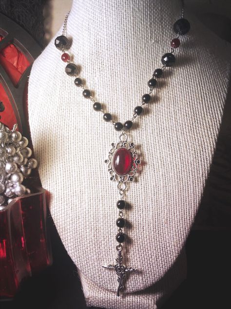 25 inch necklace with stainless steel chain and 3 1/2 inches of black and red glass beading on either side. Central pendant with red acrylic set and zinc alloy rose cross Made with love by Sacke & Sugar in Chattanooga, TN. Jewelry has small parts and is not intended for children. Follow us on Instagram for updates and sales: @sacke_and_sugar Cross Choker Gothic, Goth Things To Buy, Vampire Gothic Fashion, Calista Core, Vampire Goth Fashion, Gothic Accessories Jewellery, Baddie Jewelry, Vampire Accessories, Vamp Goth