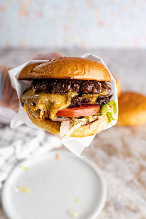 A hand holding a delicious homemade smash burger wrapped in parchment. Ground Beef Burger Recipe, Juicy Burger Recipe, Homemade Burger Patties, Burgers At Home, Burger Patty Recipe, Homemade Burger Recipe, Easy Italian Pasta Salad, Smash Burger Recipe, Burger Recipes Beef