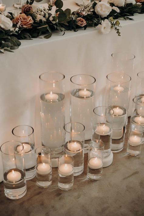 Tea Light Candles In Water, Vase With Water And Candle, Sweetheart Table Floating Candles, Cylinder Vases With Floating Candles, Candles In Glass Cylinders, Candle Centerpieces Wedding Round Table, Cylinder Vase Centerpiece Wedding, Floating Candles Wedding Centerpieces, Vases With Floating Candles