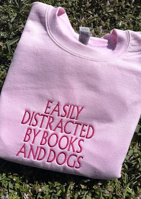 Cuddle up with your favorite book and cozy into our Distracted By Books And Dogs Sweater - where literary passion meets ultimate comfort. The perfect book lover gift or for just yourself! ✨ Embroidered Clothes Ideas, Sweatshirts Ideas, Custom Embroidered Sweatshirt, Book Lover Gifts, Book Clothes, Embroidered Crewneck, Ropa Diy, Embroidered Sweater, Embroidered Sweatshirt