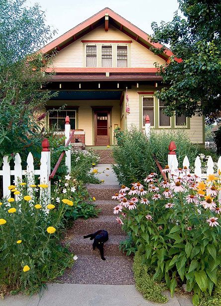 A bungalow front garden with picket fence and a profusion of daylilies, and purple coneflower shows great curb appeal. Bungalow Landscaping, Craftsman Landscaping, Arts And Crafts Bungalow, Porch Flowers, Bungalow Exterior, Craftsman Exterior, Bungalow Homes, Cottages And Bungalows, Craftsman Style House