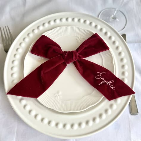 Burgundy Velvet Napkins, Xmas Decorations Table, Bows Christmas Decor, Bow Name Cards, Christmas Aesthetic Party, Christmas Party Tablescapes, Bow Table Setting, Red And White Table Decorations, Velvet Tablescape