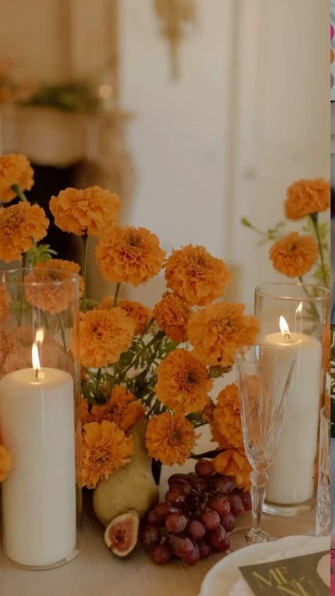 This stunning Mexican inspired wedding centerpiece features elegant white candles surrounded by vibrant cempasuchil flowers, creating a beautiful and culturally rich focal point for your special day. The combination of traditional elements and modern elegance will bring a touch of Mexico to your wedding celebration, creating a warm and inviting atmosphere for your guests to enjoy. Marigold Theme Wedding Decor, November Mexican Wedding, Mexican Wedding Flowers Centerpieces, Mexican Wedding Modern, Dia Los Muertos Wedding, Mexico Wedding Centerpieces, Mexican Culture Wedding, Mexico Wedding Florals, Dried Oranges Wedding