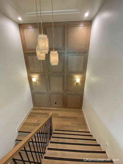 Tall accent wall in stairs using millwork molding's of stained wood Stair Wall Wood Paneling Ideas, Vaulted Ceiling Wall Moulding, High Stairwell Ideas, Wallpaper Tall Wall, Wainscoting On Tall Walls, Black Metal Interior Stair Railing, Stairway Wall Treatments, Modern Staircase Accent Wall, High Wall Staircase Decor