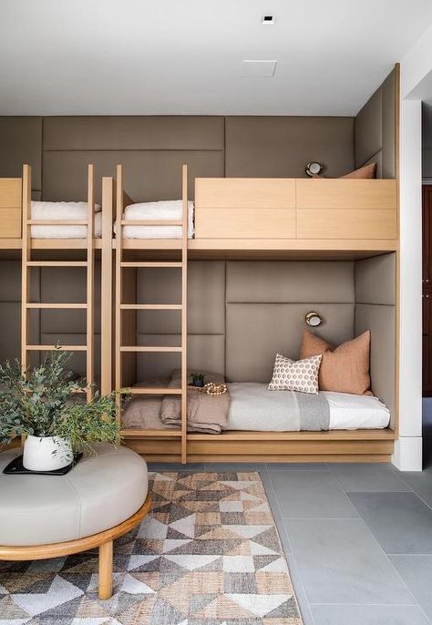 Brown leather padded trim accents the walls behind a pair of blond wood bunk beds dressed in gray and beige bedding topped with orange and gray pillows. Bunk Bed Office, Max Strus, Millwork Ideas, Beige Bedroom Decor, Bunk Bed Rooms, Bunk Beds Built In, Rustic Office, Wooden Bunk Beds, Built In Bunks